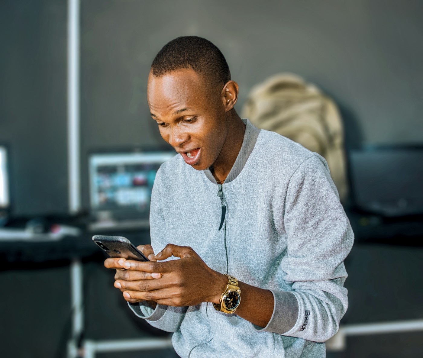 A man in Nigeria smiling with delight at something on his phone